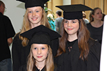 Children in graduation gowns
