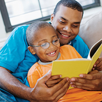 Father and son reading a book together