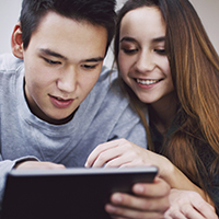 Two teenagers looking at a tablet device