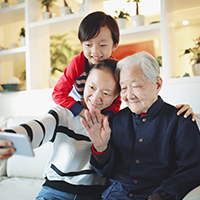 Young boy taking photo with his mother and grandfather