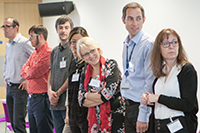 People standing in a row, looking to their left