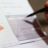 Person holding a pen over a finance report