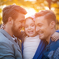 Two men holding a young girl