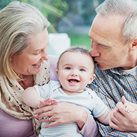 Grandmother and grandfather holding young baby