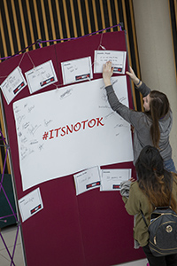 Student writing on #ITSNOTOK thoughtboard
